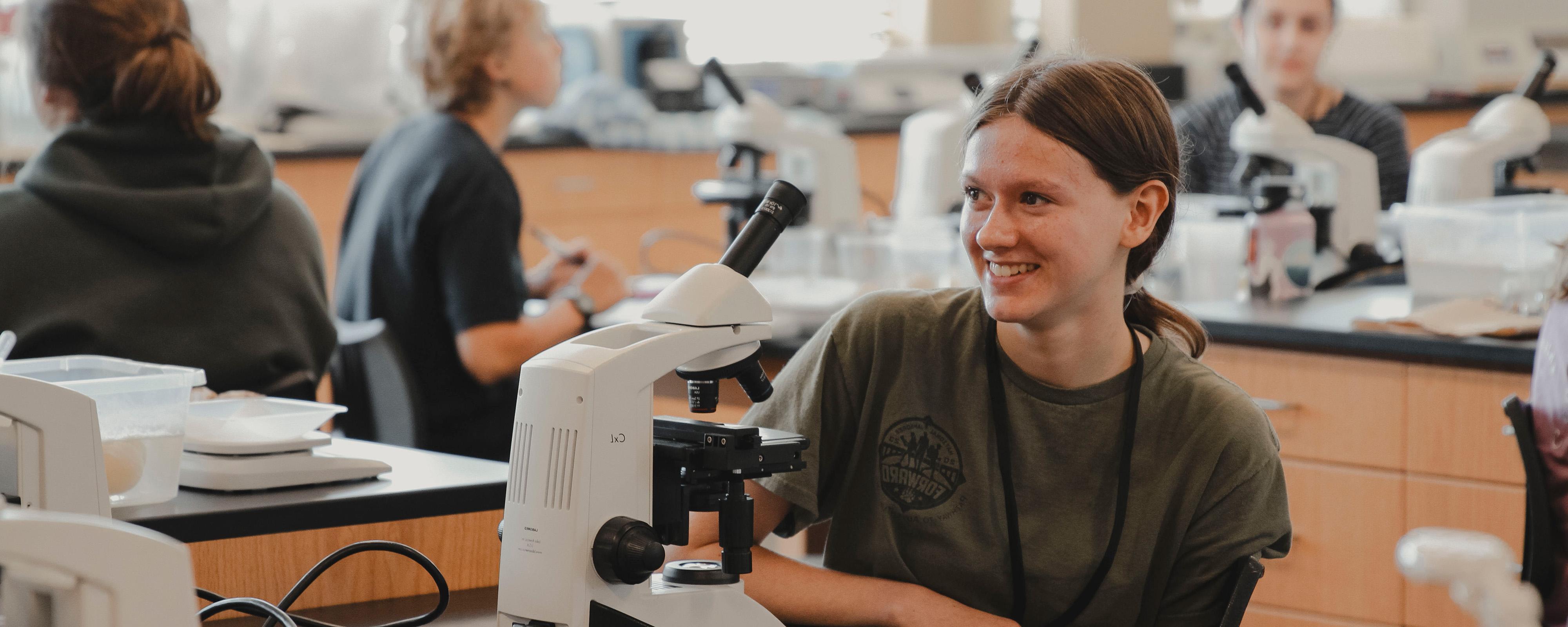 A BCYC student uses a microscope